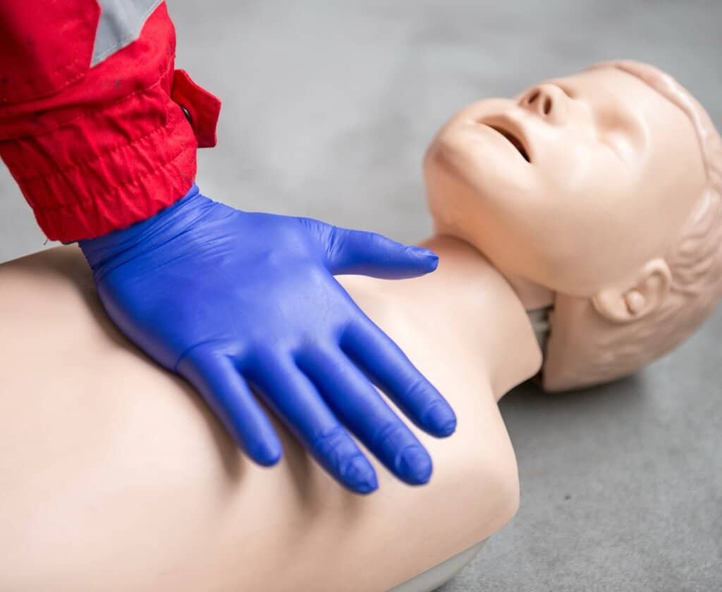 CPR being performed on a mannequin that is child sized  